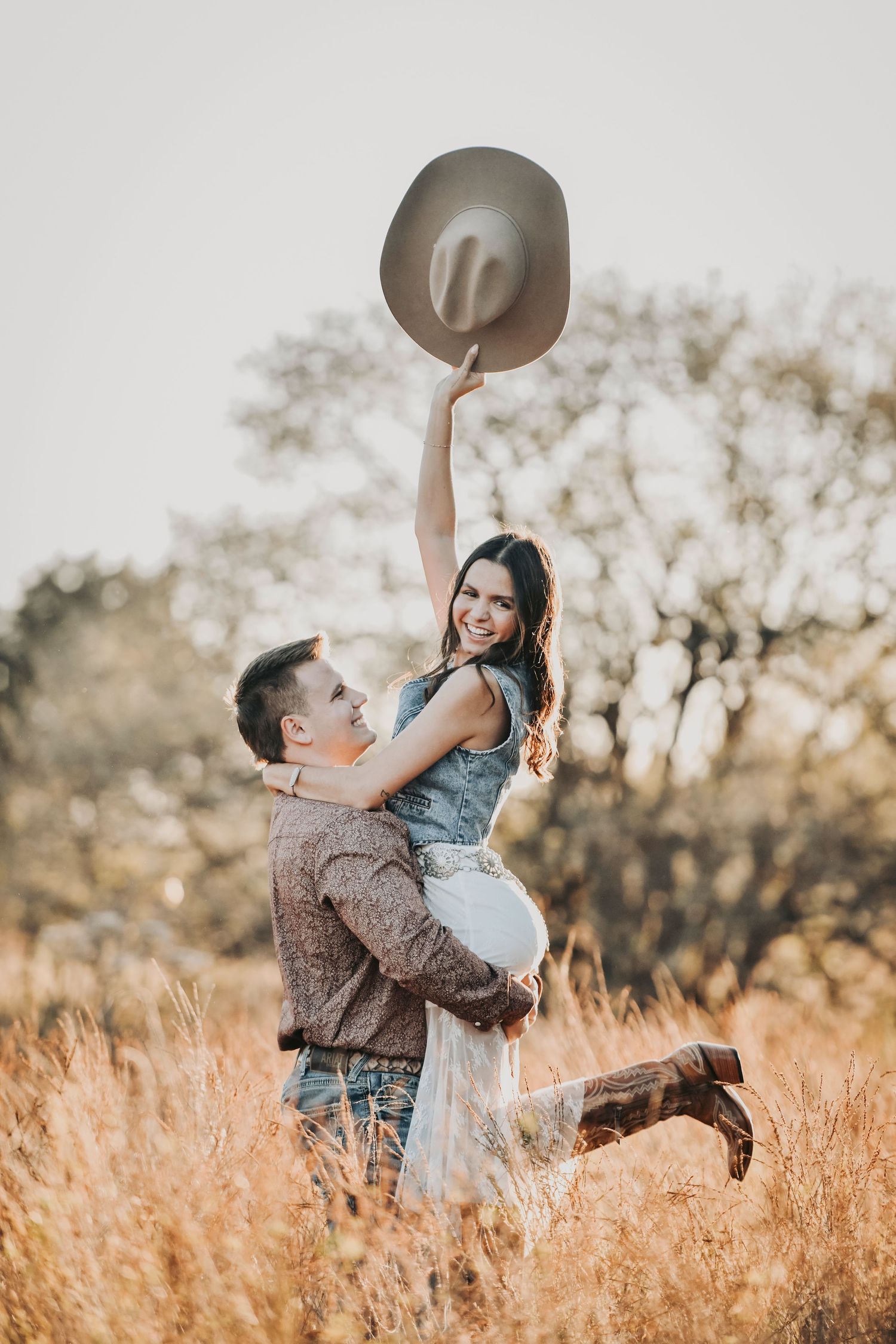 Engagement photos of a man lifting his fiancée during a playful outdoor engagement session