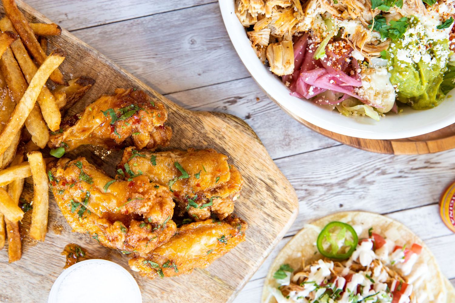 Restaurant spread of comfort foods including fries, sandwiches and salads.