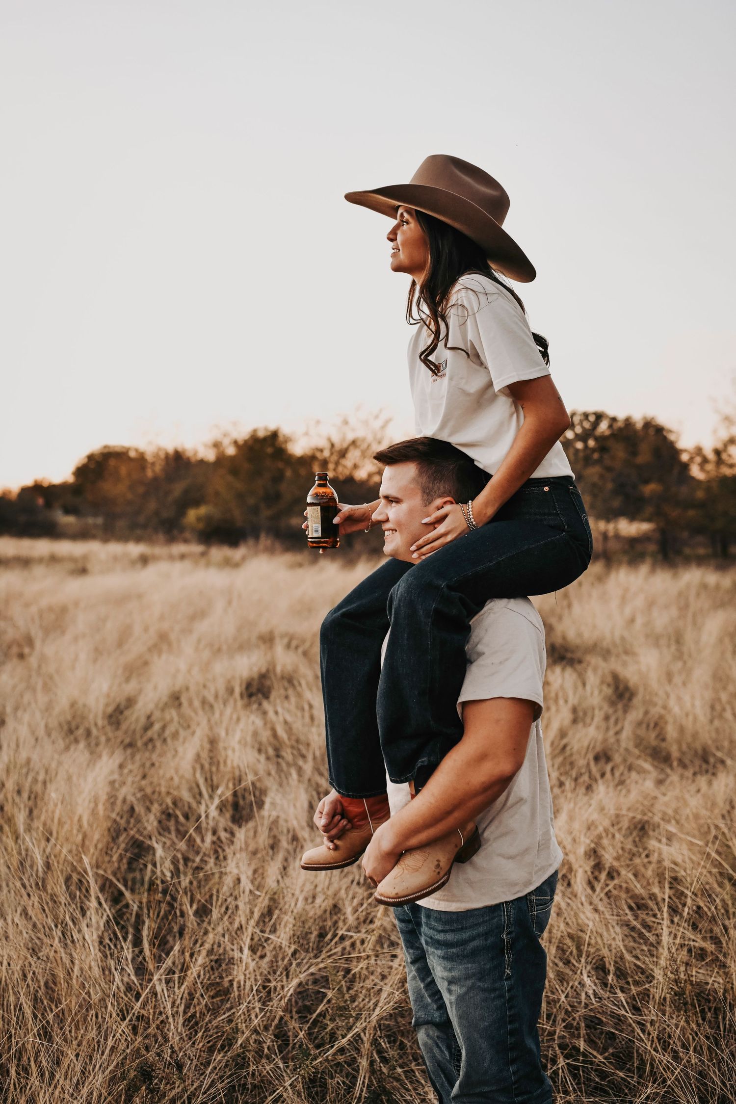 Artful engagement photography in dallas capturing a couple at sunset in a scenic open field