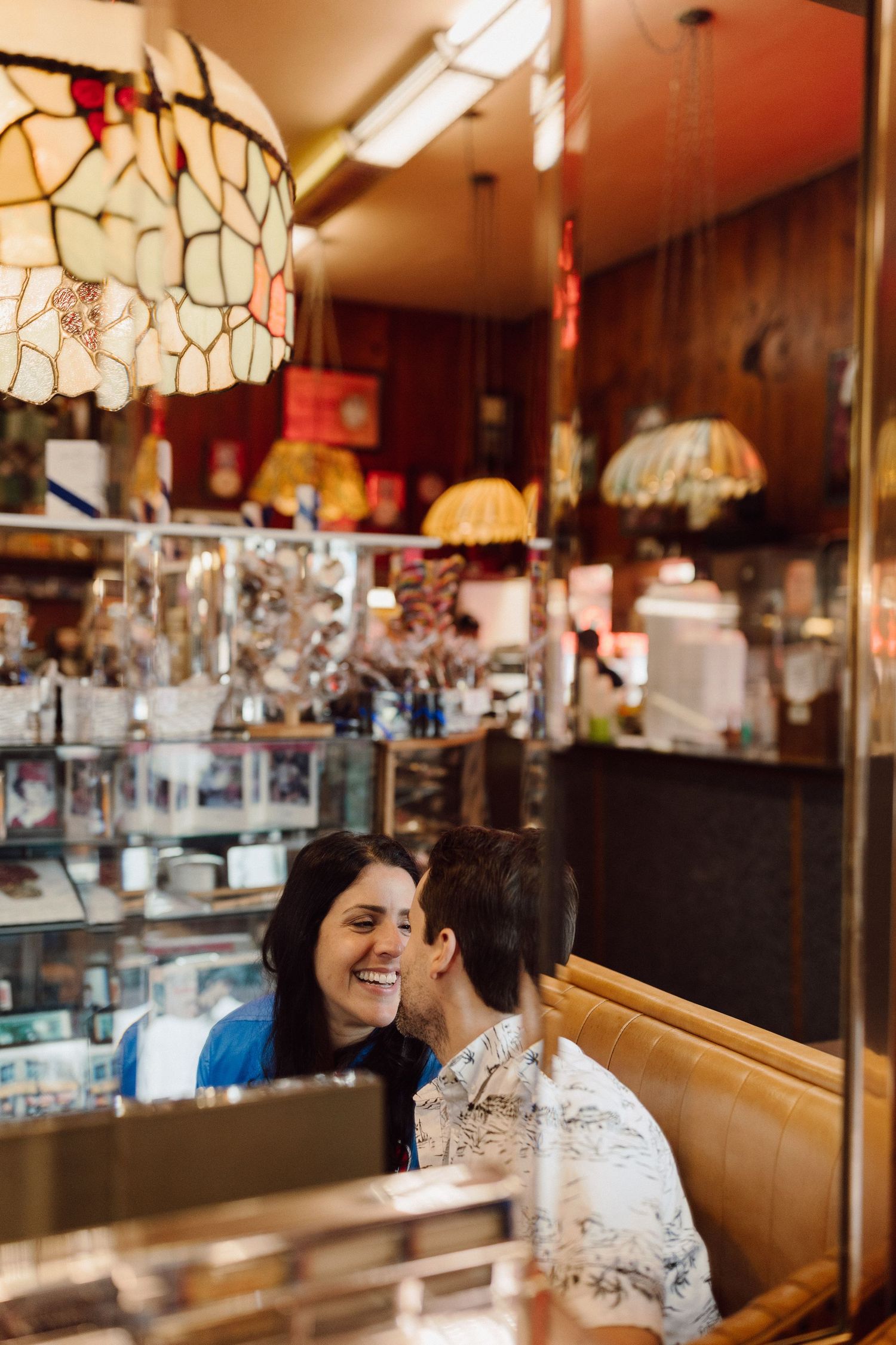 Intimate moment between diners at a classic American restaurant with vintage lighting.