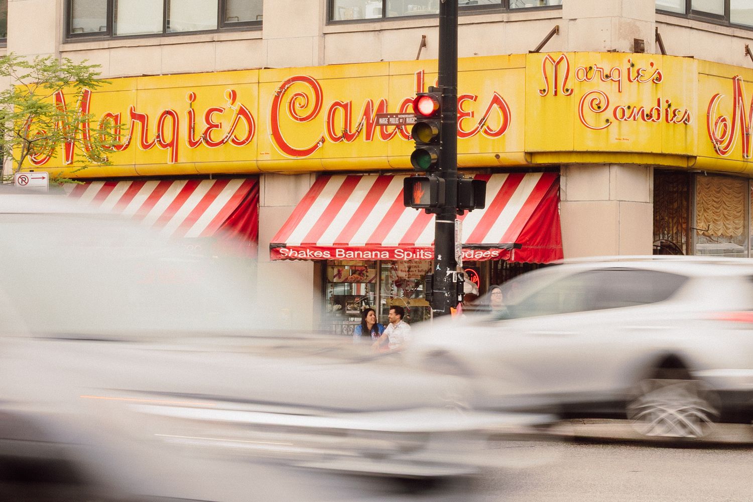 Exterior view of retro ice cream shop with yellow signage and awnings.