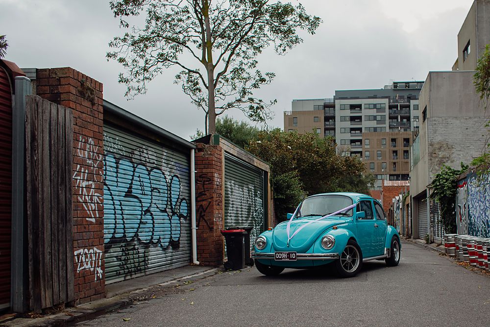 A series of urban alleyway scenes featuring a vintage blue Volkswagen Beetle parked near graffiti-covered walls.