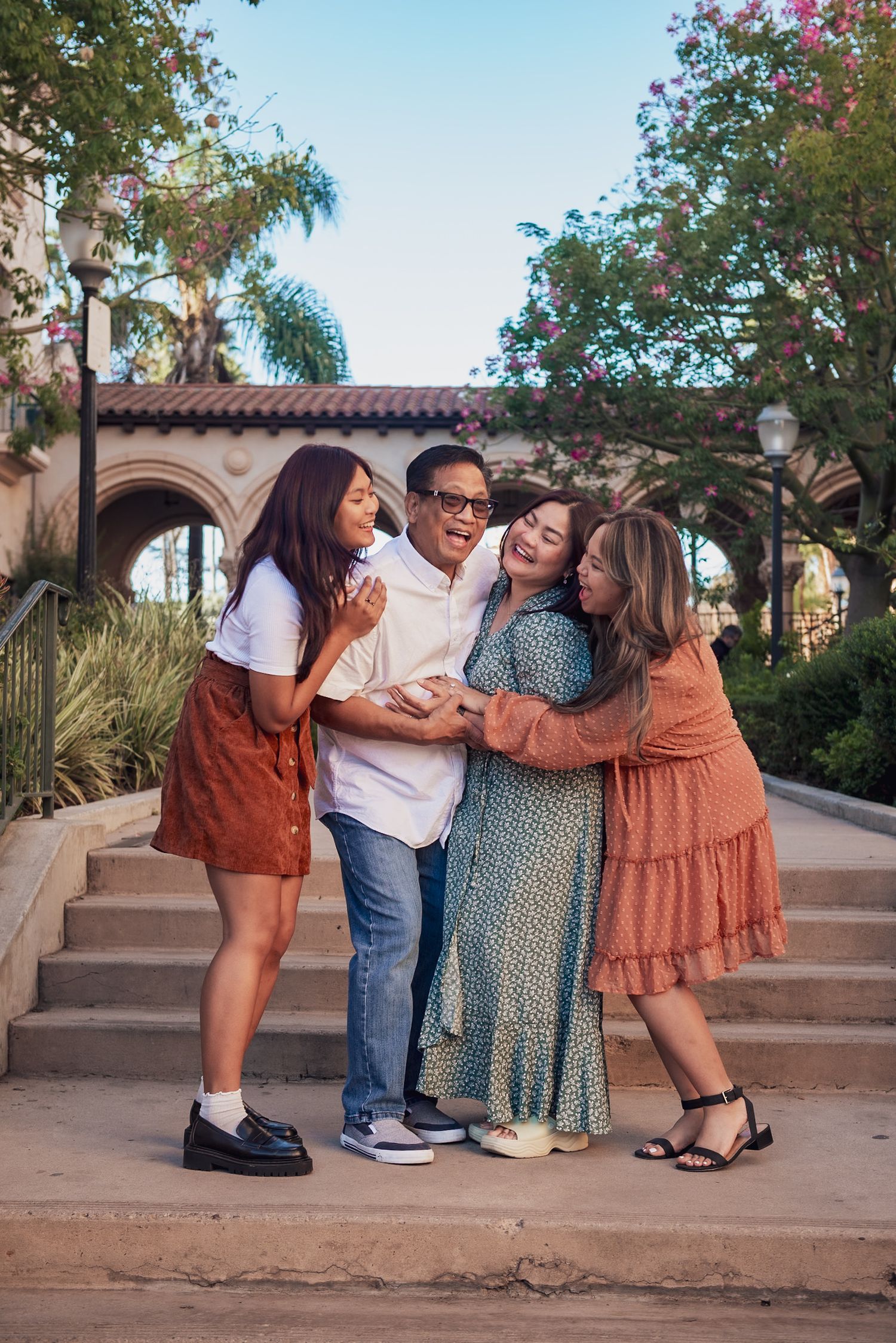 A group shares joyful moments together in a sequence of playful poses on outdoor steps at sunset.