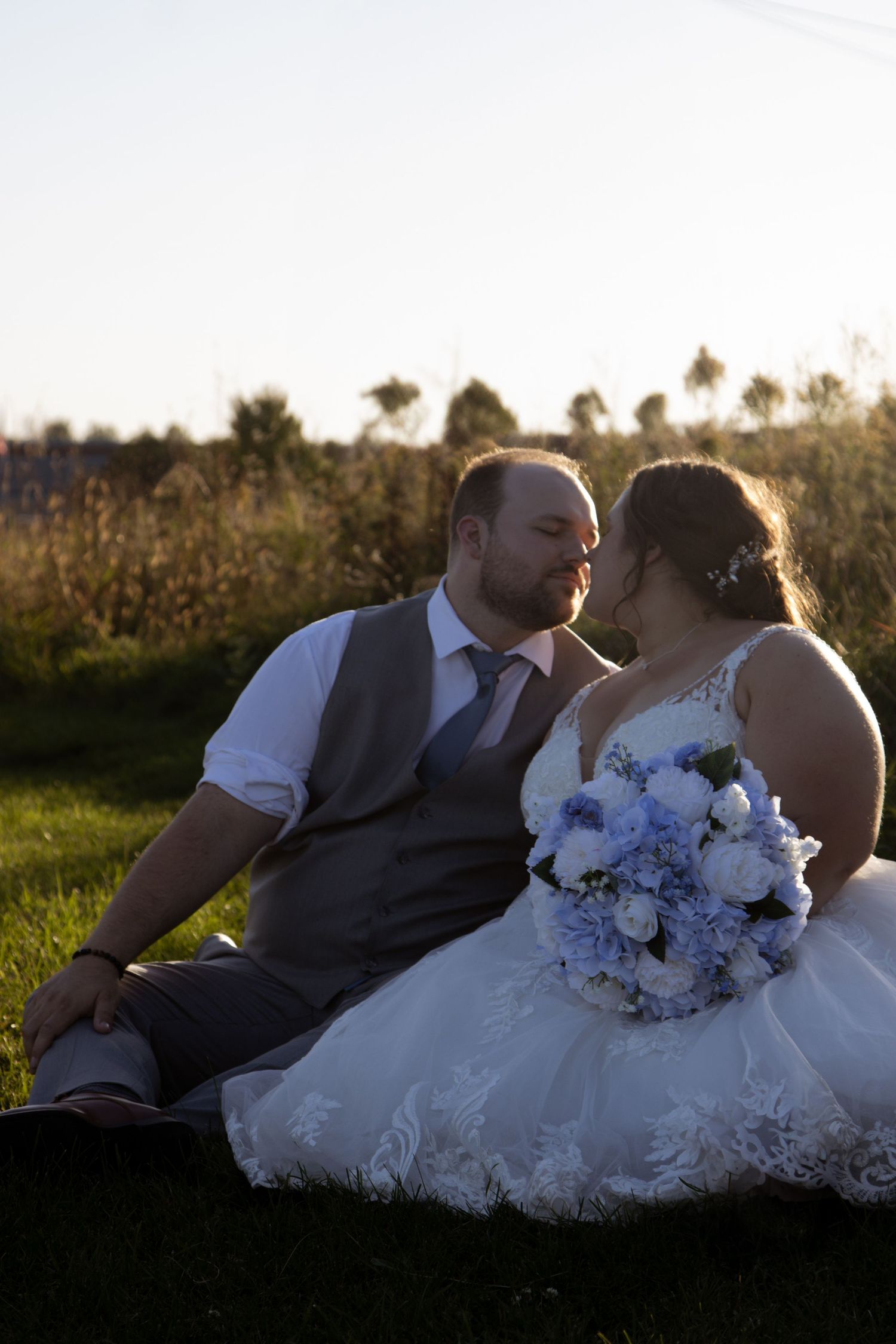Newlyweds sharing intimate moment with bride holding bouquet.