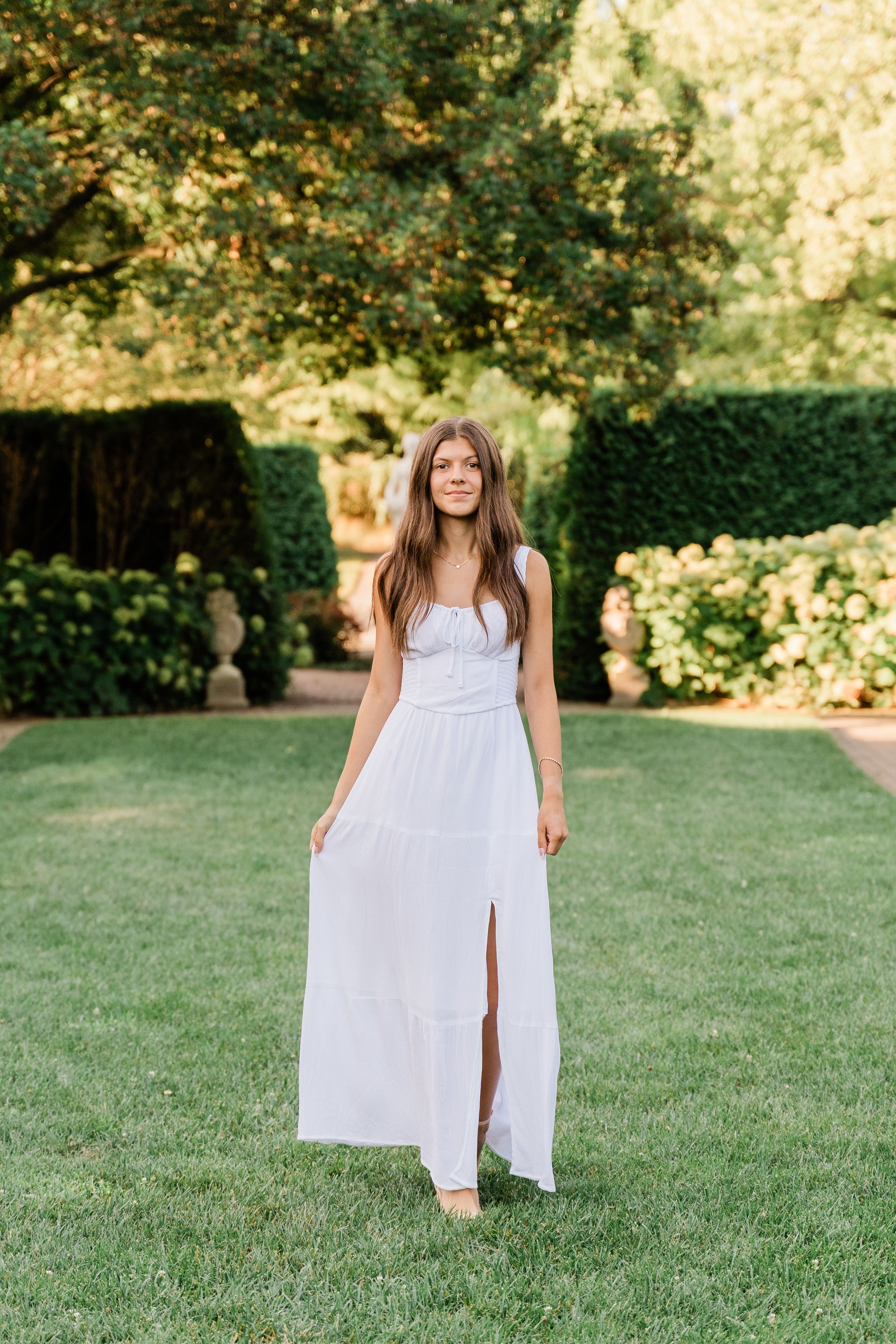 A series of photos showing a white summer dress on a grassy lawn with trees and hedges in the background.