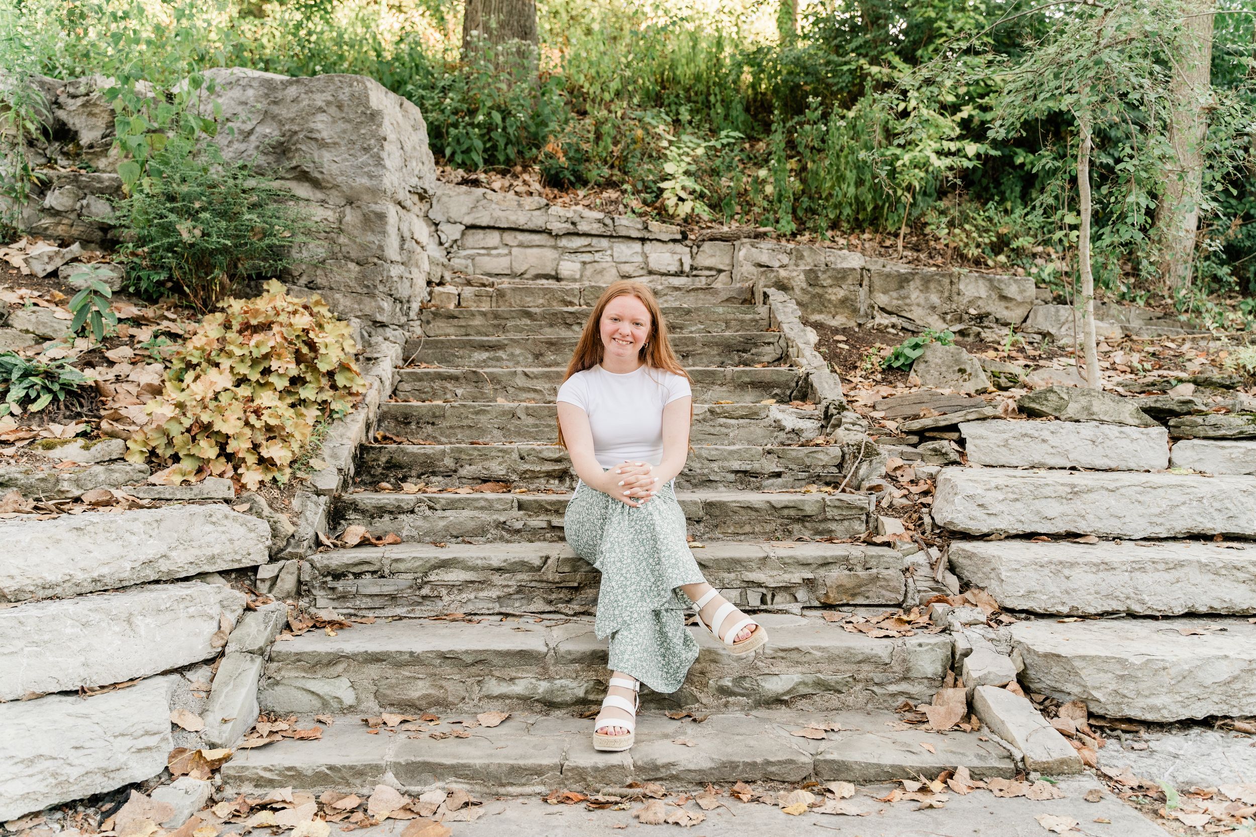 A collection of casual outdoor portraits taken on stone steps surrounded by greenery and natural landscaping.