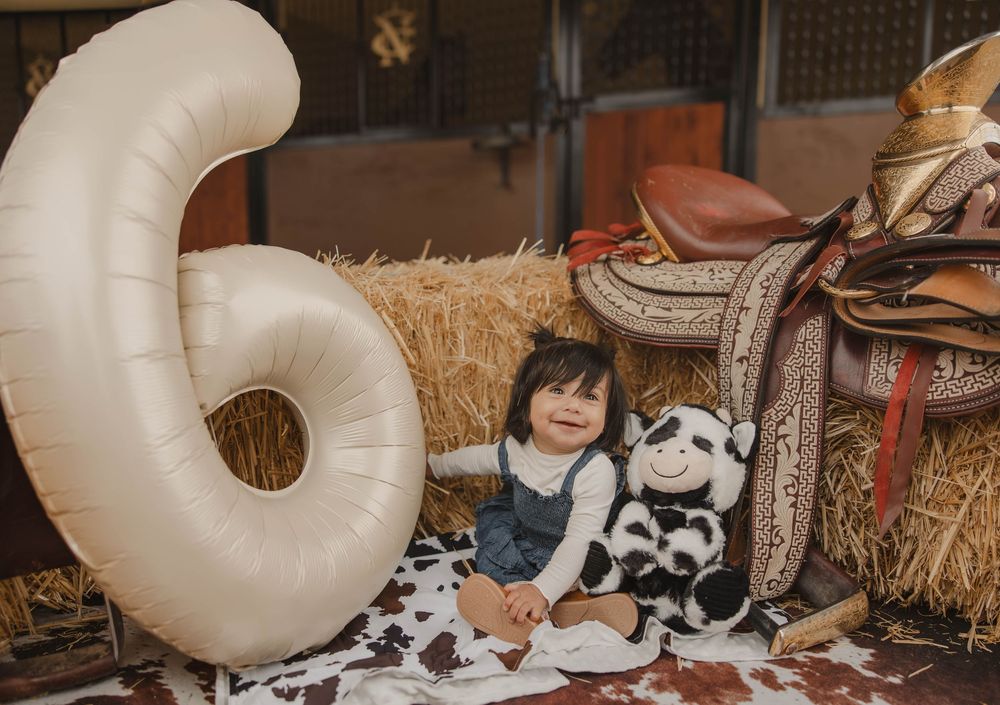 Rustic barn setting with hay bales and western decorative elements.