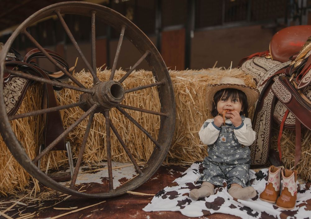 Rustic barn interior with hay bales and vintage wagon wheel decorations.