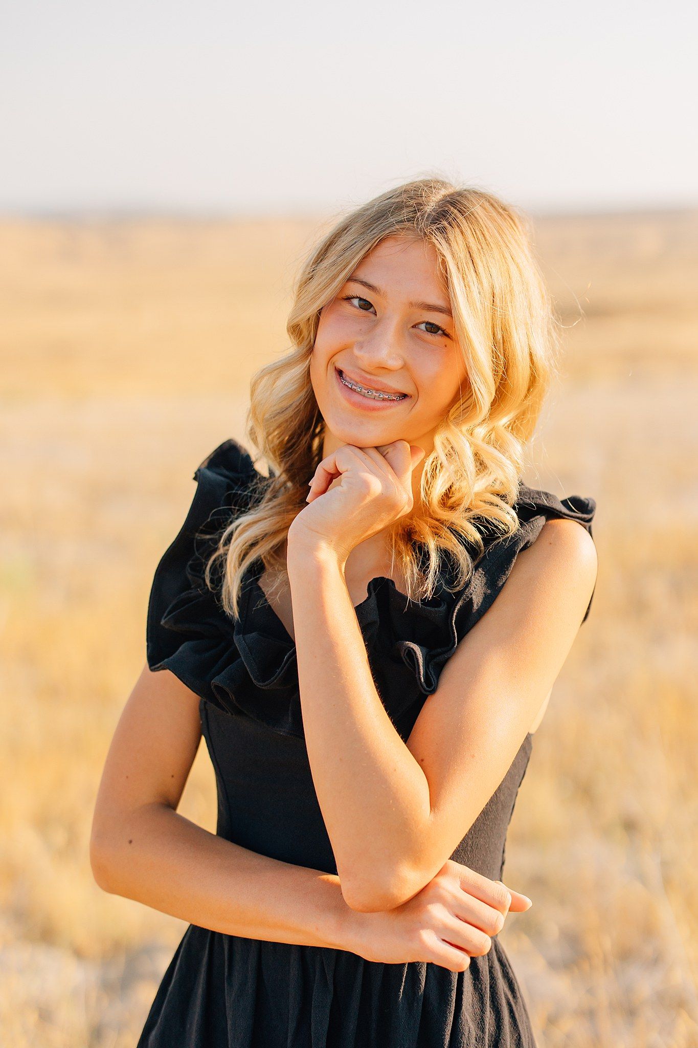 A series of portraits taken in a golden wheat field during sunset showing joyful expressions and casual poses.