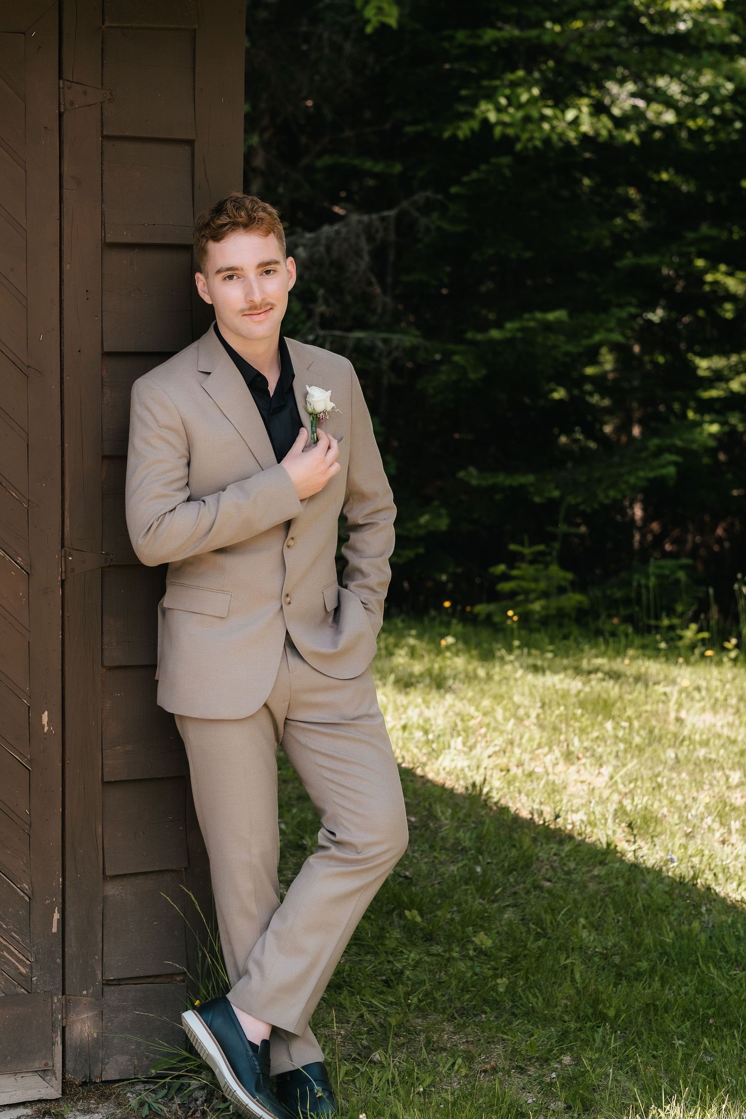 A person in a beige suit poses playfully in multiple shots against a rustic wooden structure in a sunny outdoor setting.