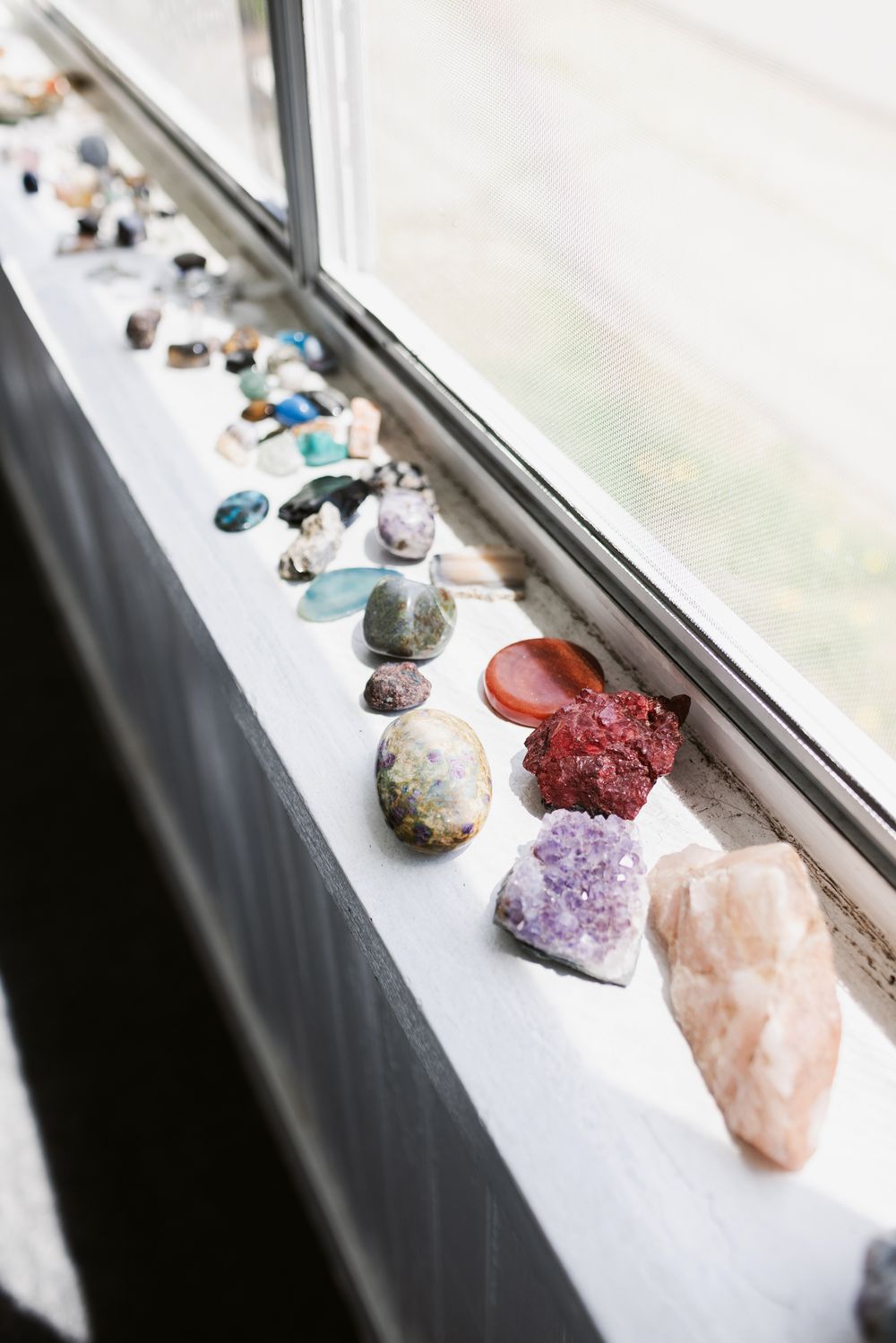 A rock collection rests on a sunny windowsill for a newborn photo shoot in Berwick, Maine Seacoast New Hampshire.