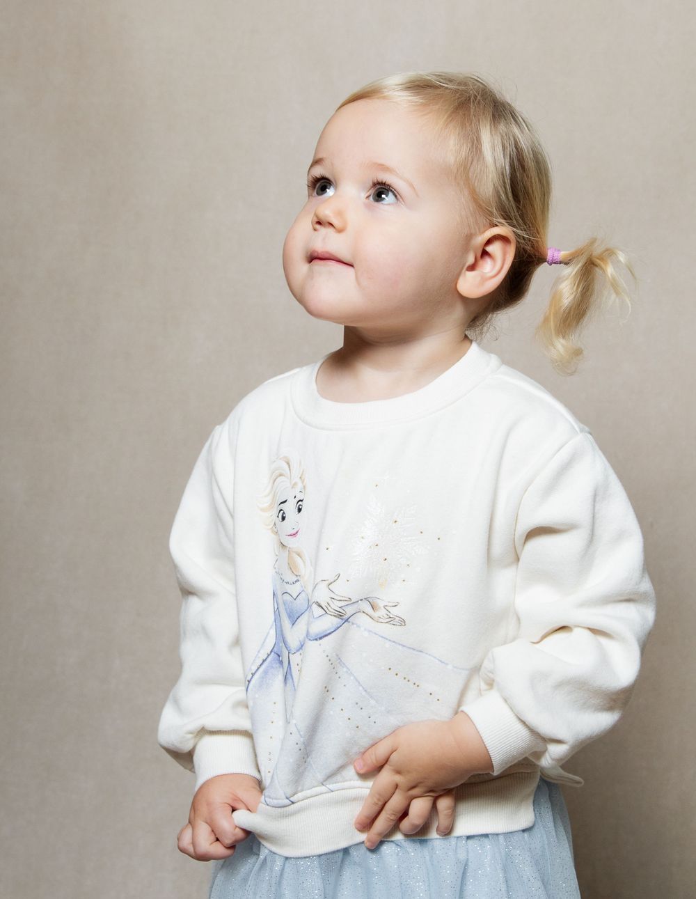 Natural photo of a young girl looking up in a studio setting.