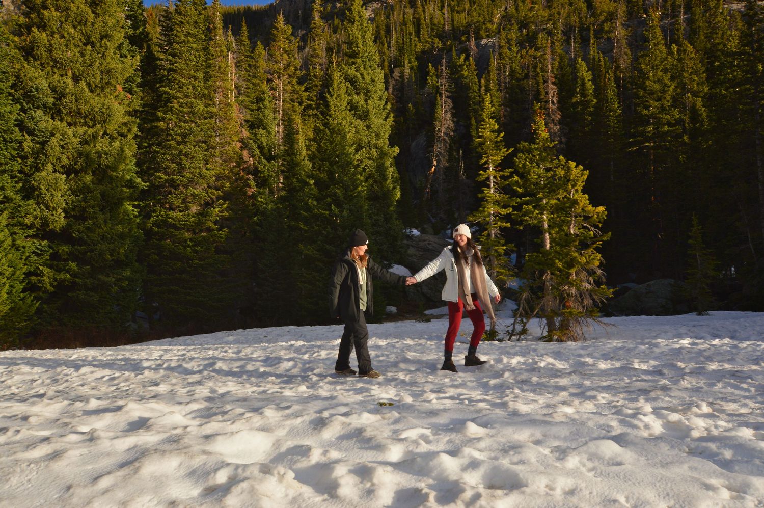 Female couple walking through the open space at Dream Lake. Just engaged. Photographer: Pixcapades