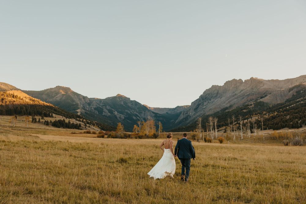 Groom leading bride in Mountains of Grizzly Creek Ranch Wedding in Emigrant Montana captured by Pray Montana Wedding Photographer