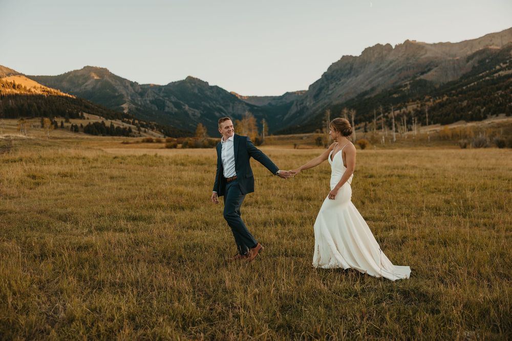 Groom leading bride in Mountains of Grizzly Creek Ranch Wedding in Emigrant Montana captured by Pray Montana Wedding Photographer