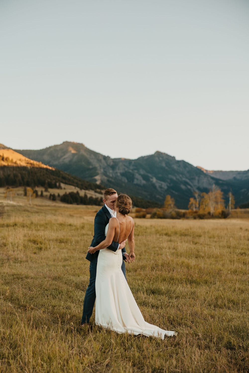 Couple embraces in Mountains of Grizzly Creek Ranch Wedding in Emigrant Montana at sunset captured by Pray Montana Wedding Photographer