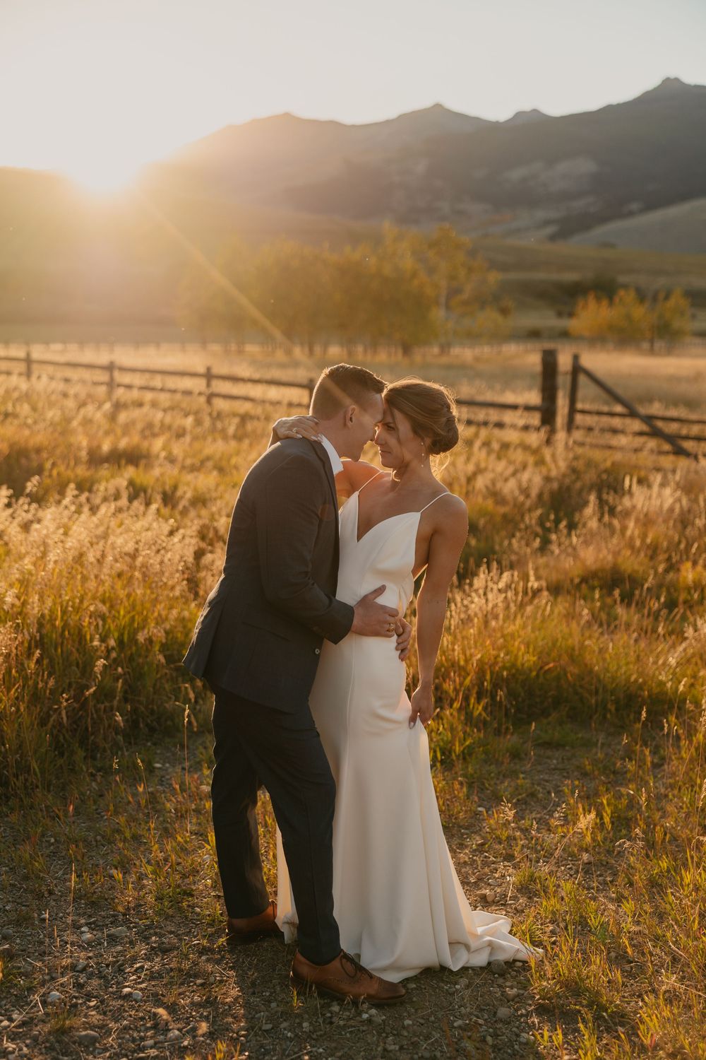 Couple embraces in Mountains of Grizzly Creek Ranch Wedding in Emigrant Montana at sunset captured by Pray Montana Wedding Photographer