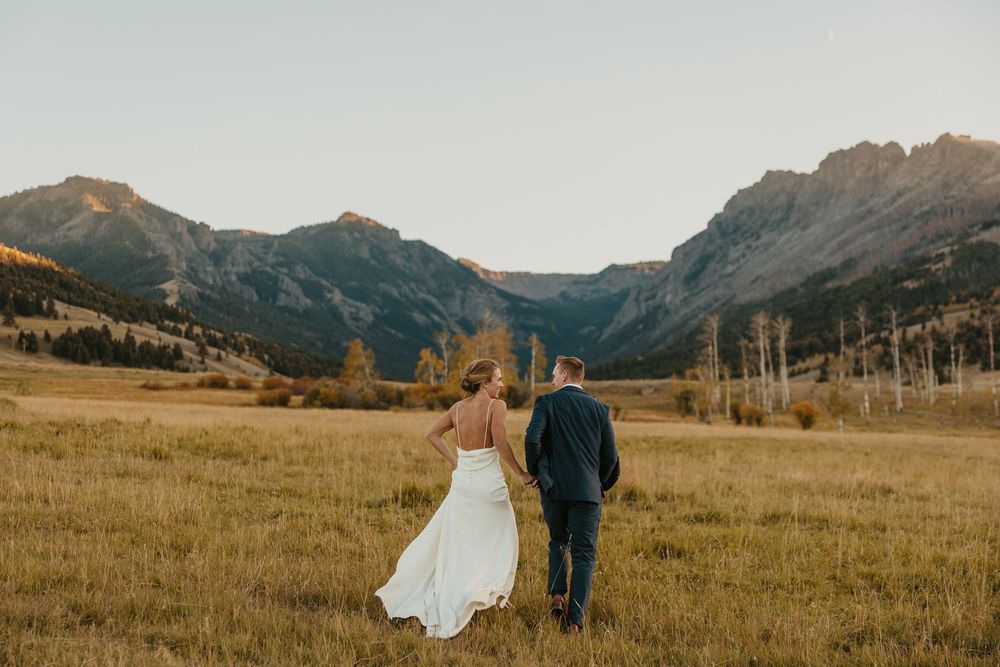 Groom leading bride in Mountains of Grizzly Creek Ranch Wedding in Emigrant Montana captured by Pray Montana Wedding Photographer