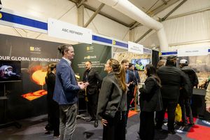 Busy trade show floor with ABC Refinery booth, attendees networking at an indoor exhibition event.