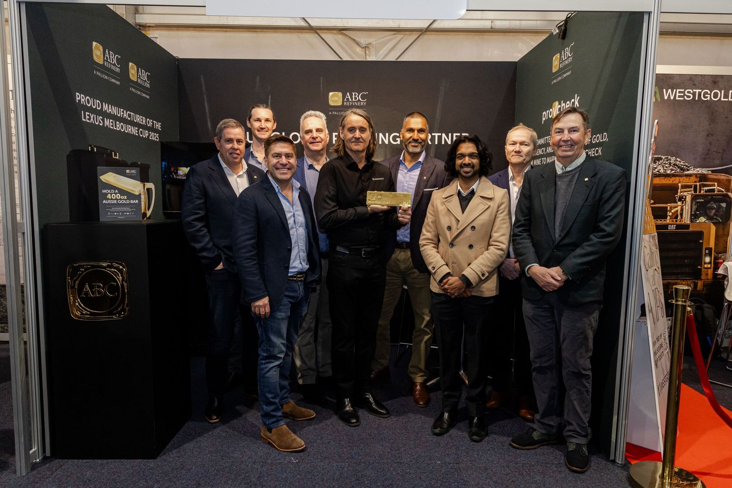 Group of professionals posing together at ABC Mining trade show booth, celebrating an award at an industry exhibition.