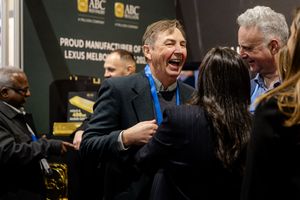 Man laughing joyfully at ABC manufacturer event near Lexus Melbourne proud manufacturer display booth.