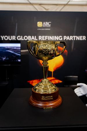 Gold Lexus Melbourne Cup 2022 trophy displayed on wooden base at ABC Refinery global refining partner exhibit.