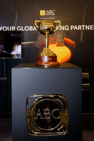Gold trophy on display at ABC Refinery booth with Your Global Refining Partner banner in background.