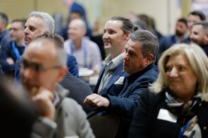 Business professionals seated and engaged during a corporate conference or seminar presentation.