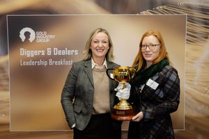 Two women holding a gold trophy cup at the Gold Industry Group Diggers & Dealers Leadership Breakfast event.