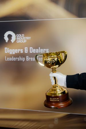 White-gloved hand presenting Lexus Melbourne Cup 2025 trophy at Diggers and Dealers Leadership Breakfast.