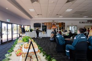Catered buffet spread with sandwiches and fresh vegetables in bright community event venue.