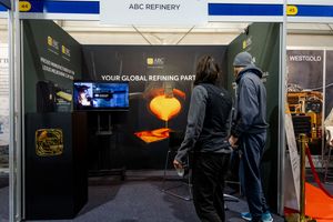 Two attendees viewing ABC Refinery global refining partner display booth at mining expo.