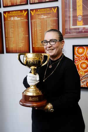 Woman in black holding the Melbourne Cup trophy at Kambalda Football Club.