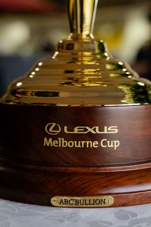 Close-up of the Lexus Melbourne Cup trophy on a wooden base with ABC Bullion branding.