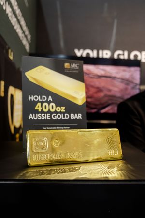 ABC Refinery 400oz Australian gold bar on display with promotional signage at an exhibition.