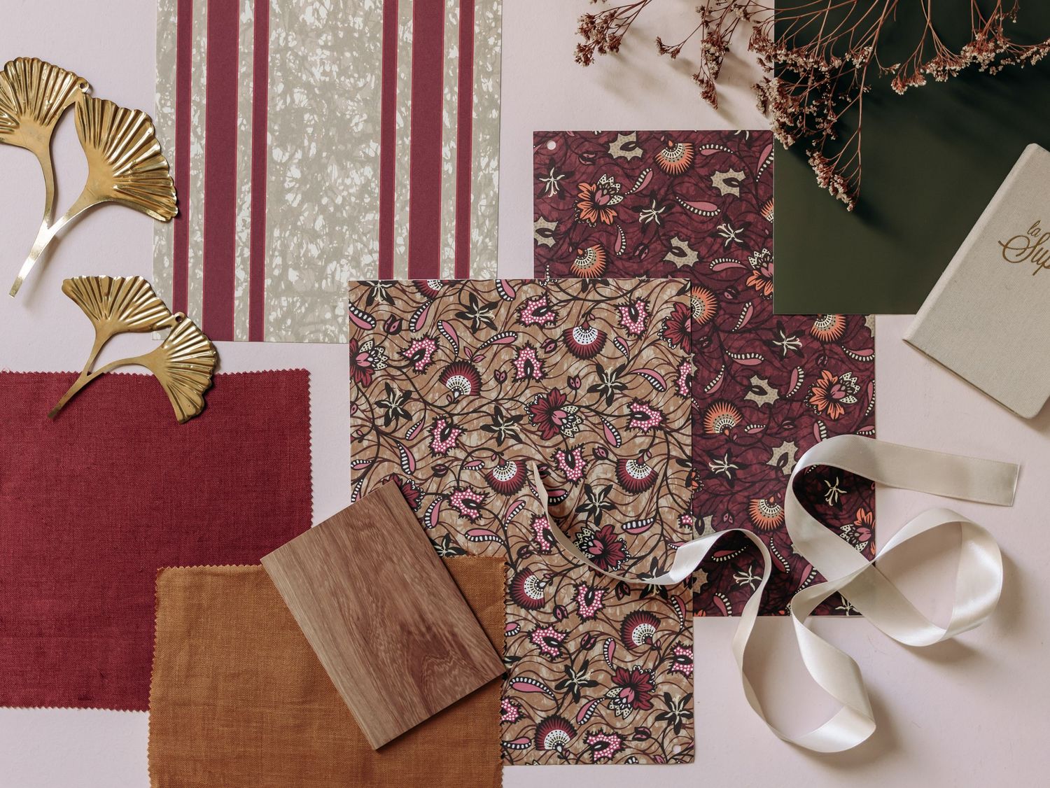 Flat lay interior design mood board with fabric swatches, paint samples, and decor inspiration on a wooden surface.