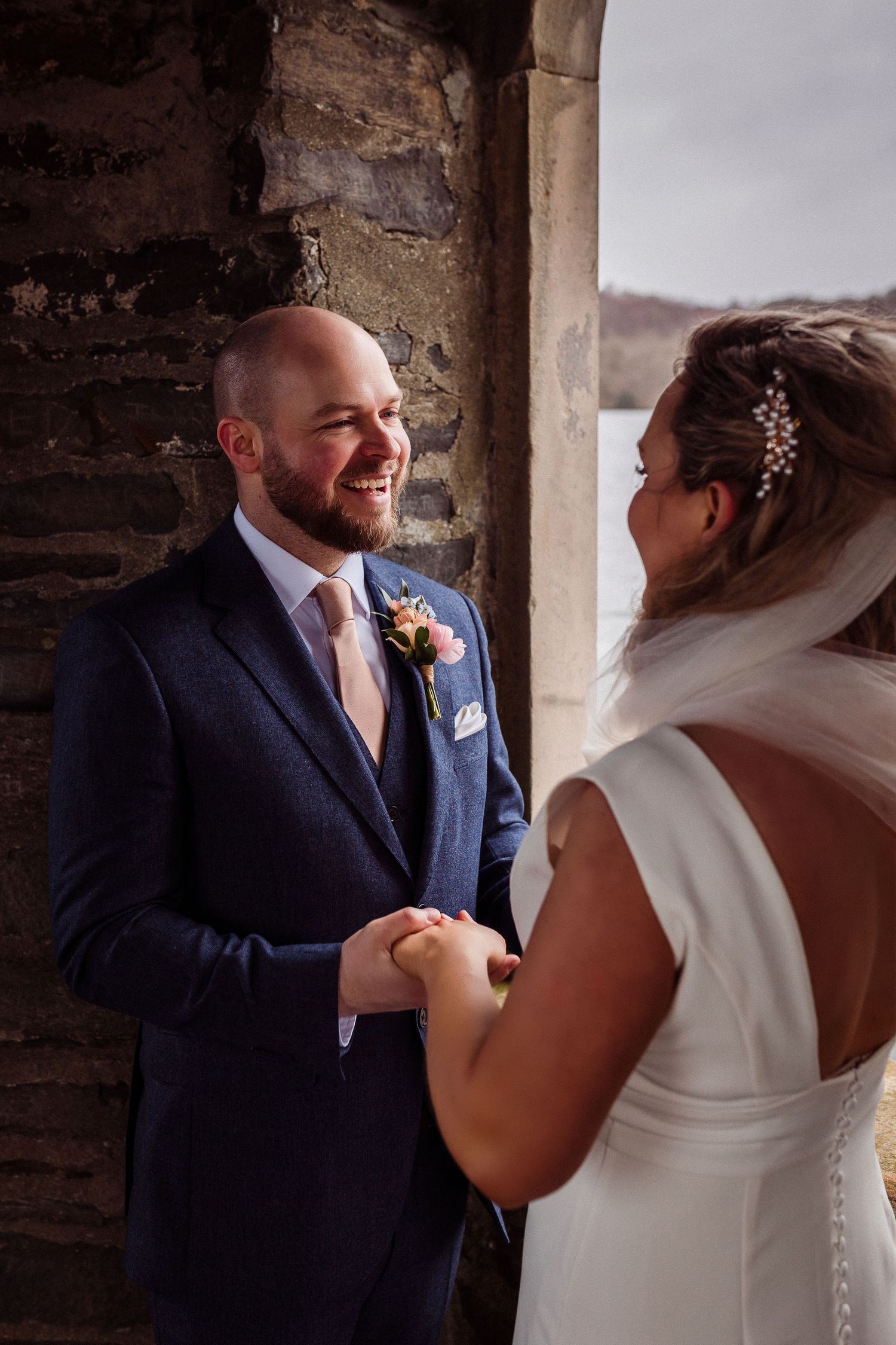 Couple standing together beneath the stone arch at Storrs Hall