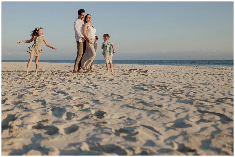 Punta Mita family photos, family walking together on a white sandy beach at sunset.