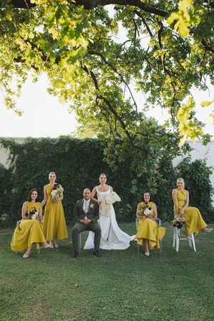 Bride and groom with bridesmaids posing for an editorial photograph