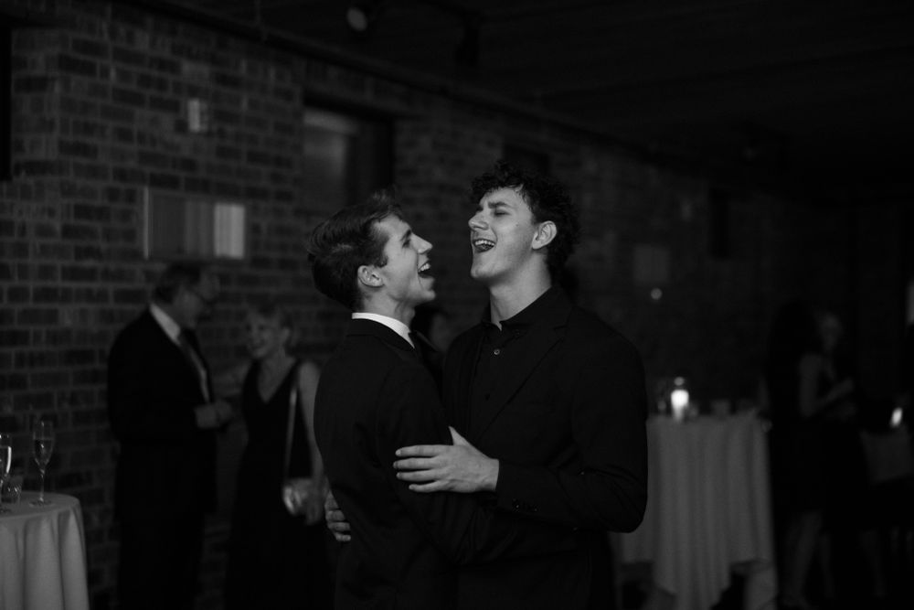 Two people share a joyful embrace on the dance floor at a wedding reception.