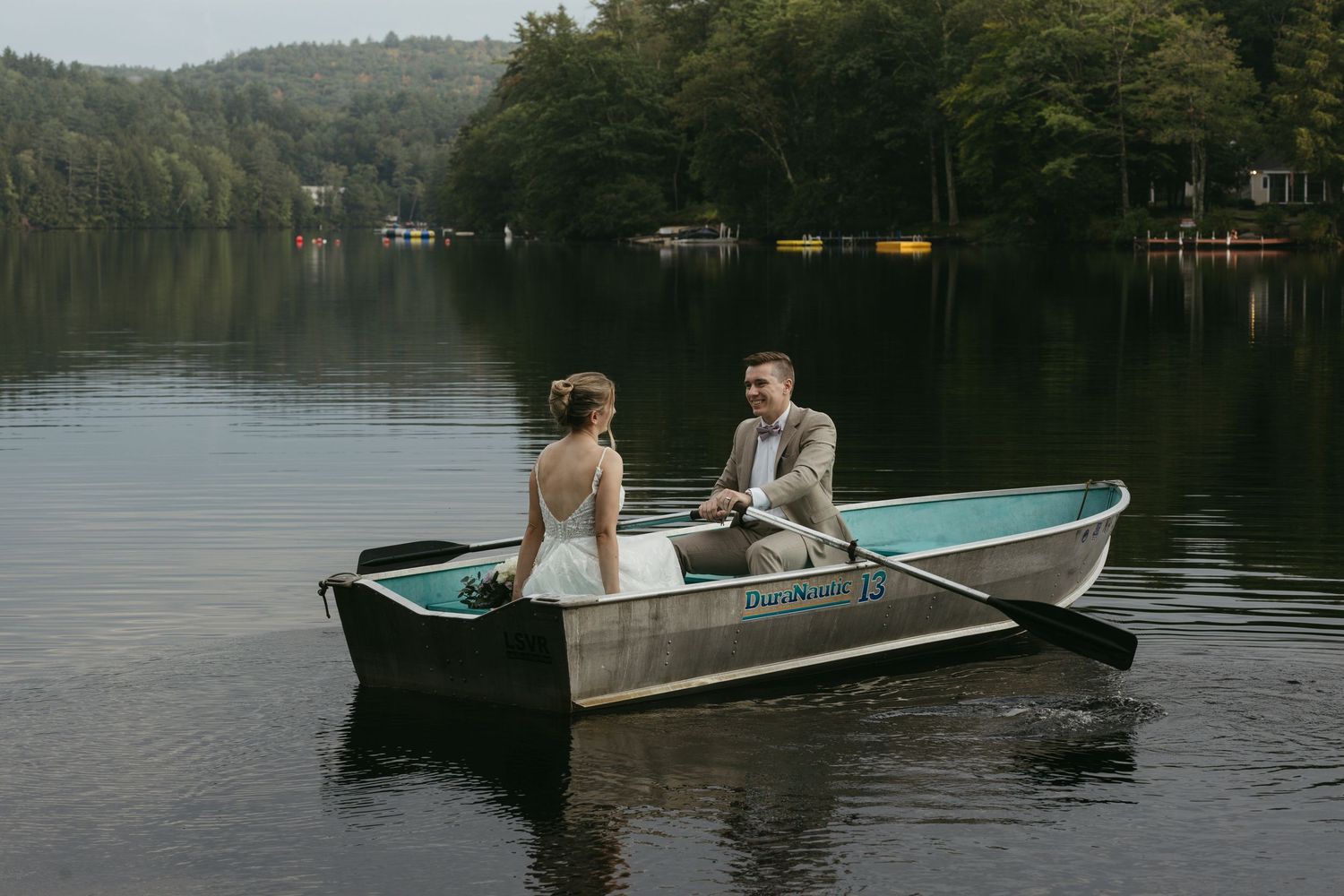 Bride and groom on row boat during wedding in New hamshire shot by lemon & honey Co.