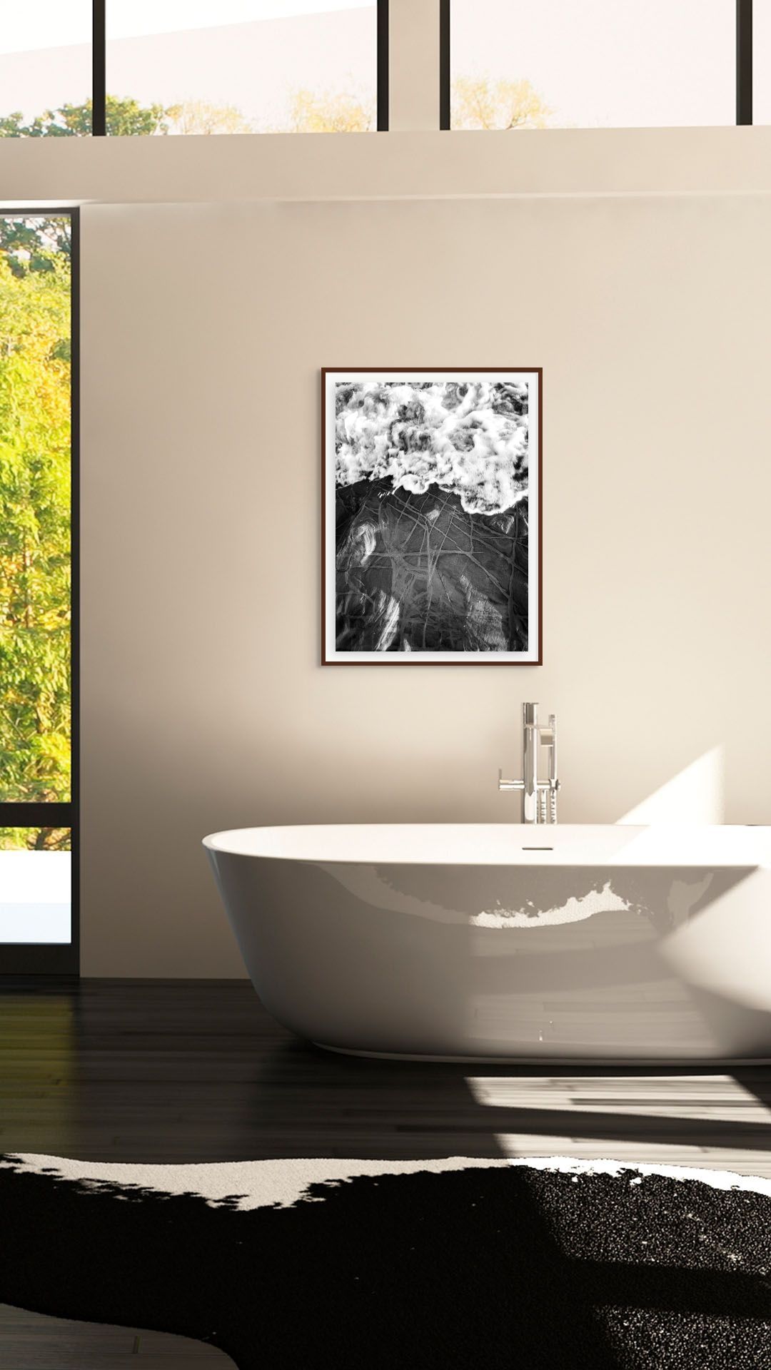 Modern living room with white sofa, rattan stool, wood side table, and black and white ocean wave framed wall art.