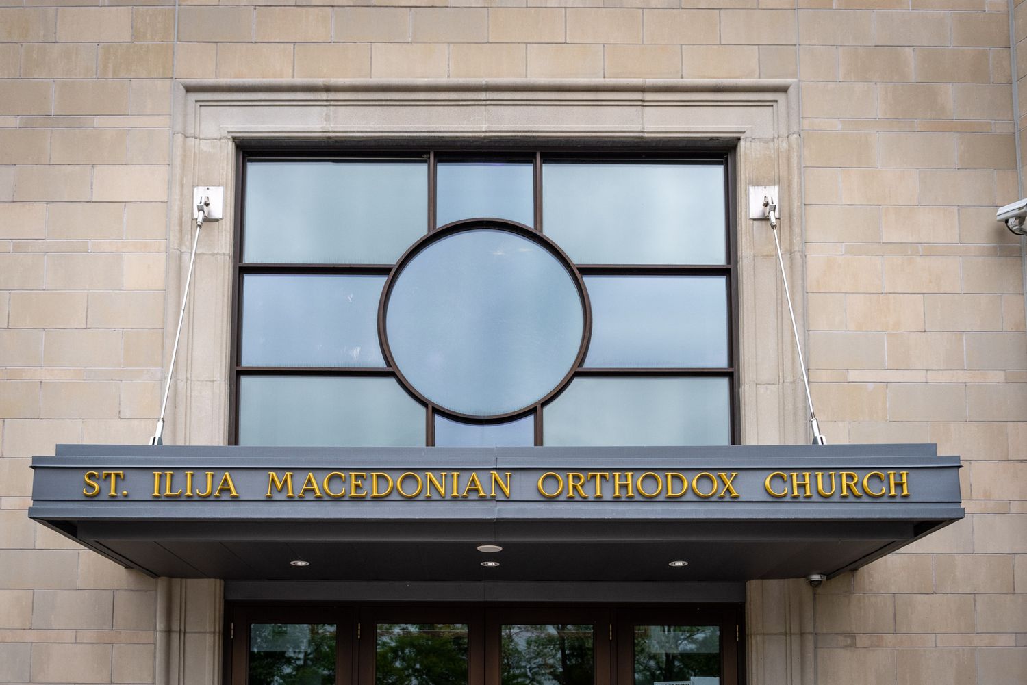 St. Ilija Macedonian Orthodox Church exterior entrance with gold lettering above doors.
