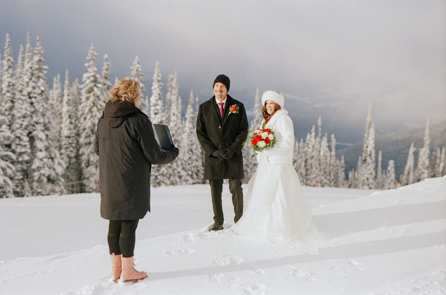 35 mm film photo of bride and groom on the ski slopes during their Revelstoke elopement ceremony surrounded by snowy trees