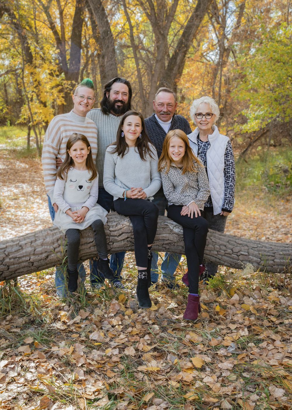 a family gathered together smiling, on an autumn day.