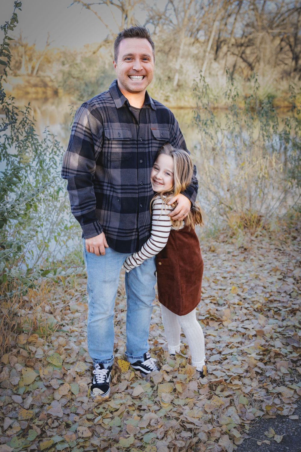 a father holding his young daughter while she hugs him.