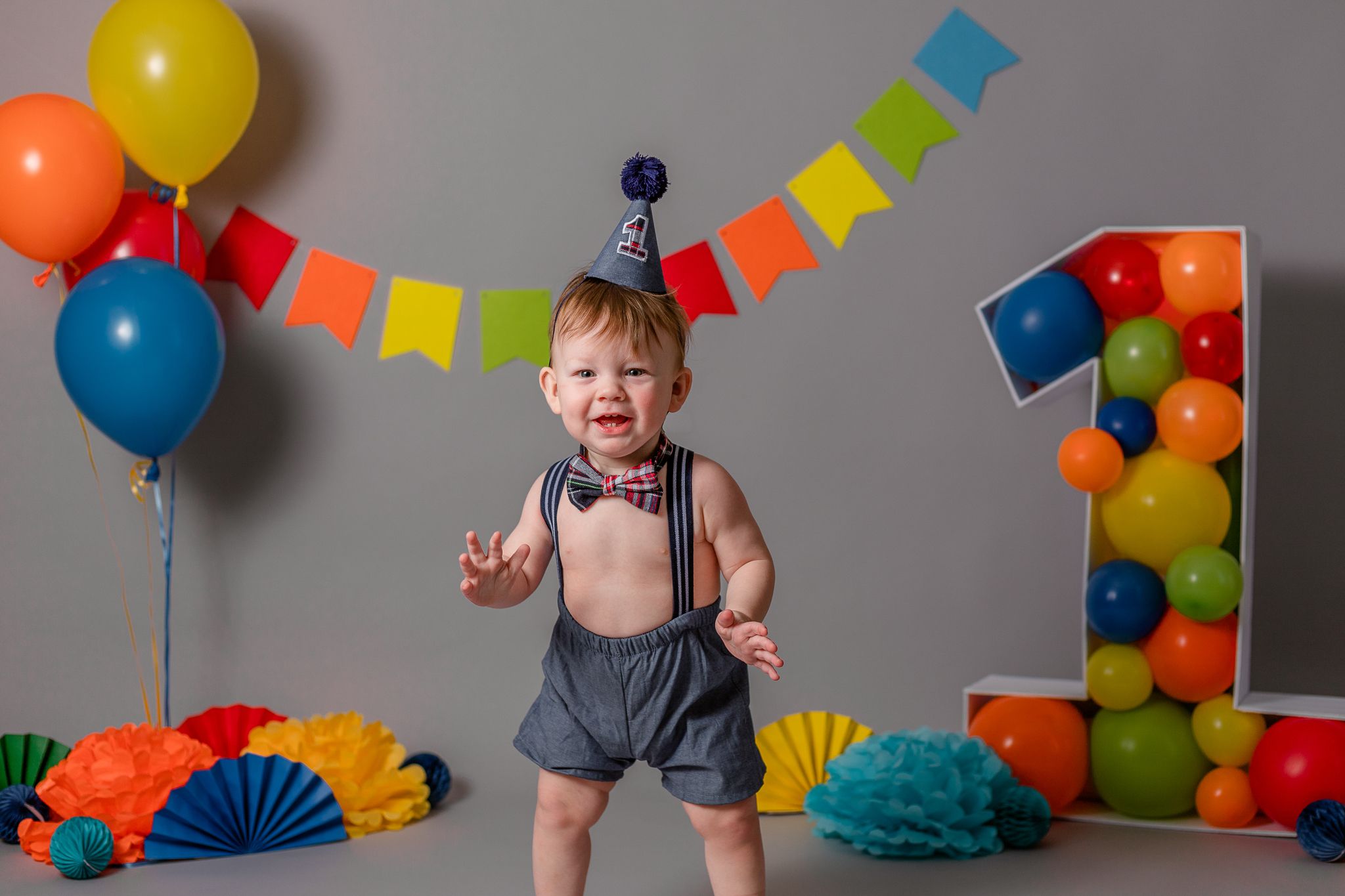 boy standing at first birthday cake smash session