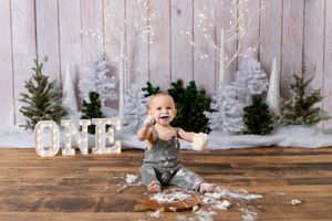 winter wonderland cake smash. boy holding cake