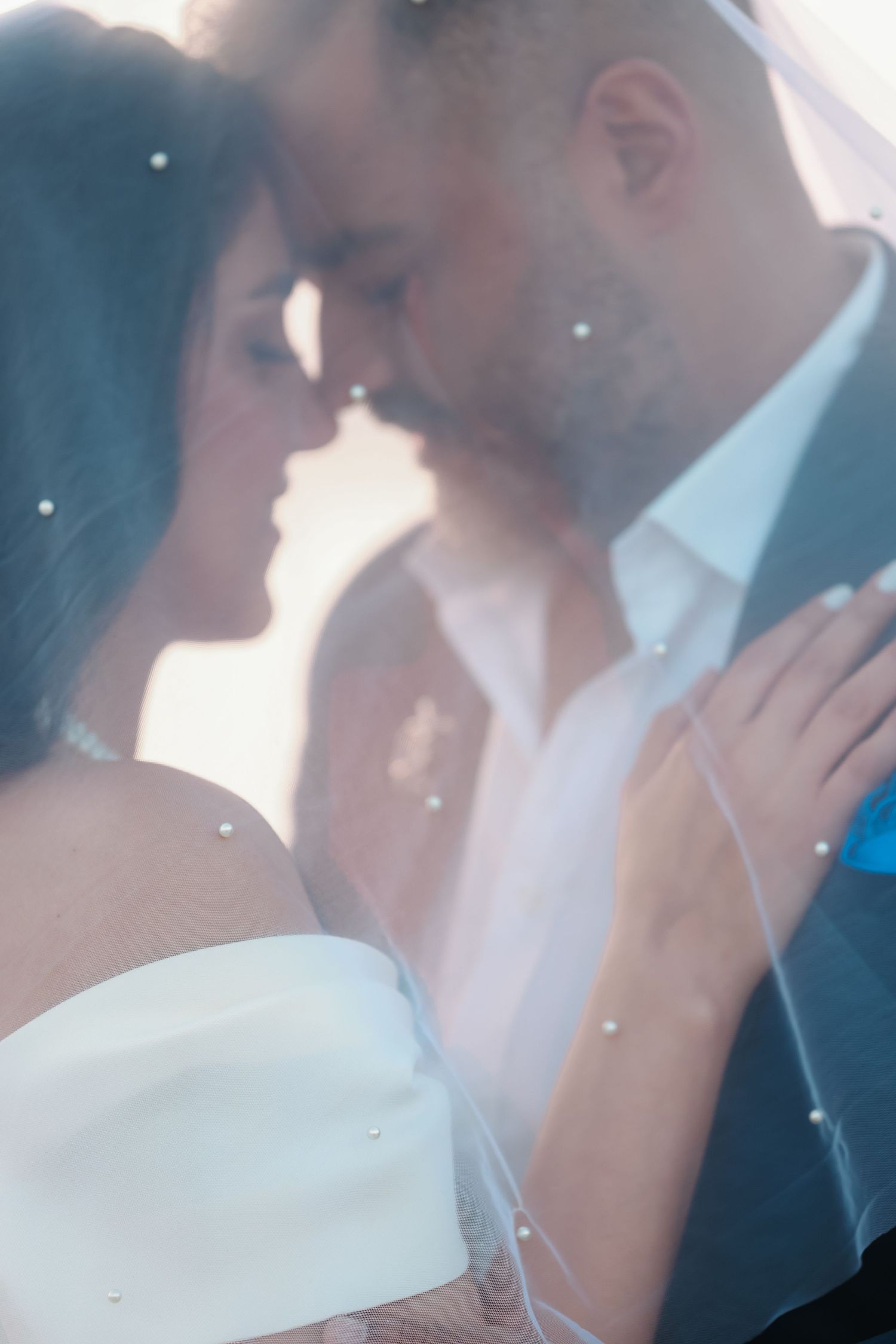 Soft focus romantic wedding portrait with sunlight creating ethereal atmosphere.