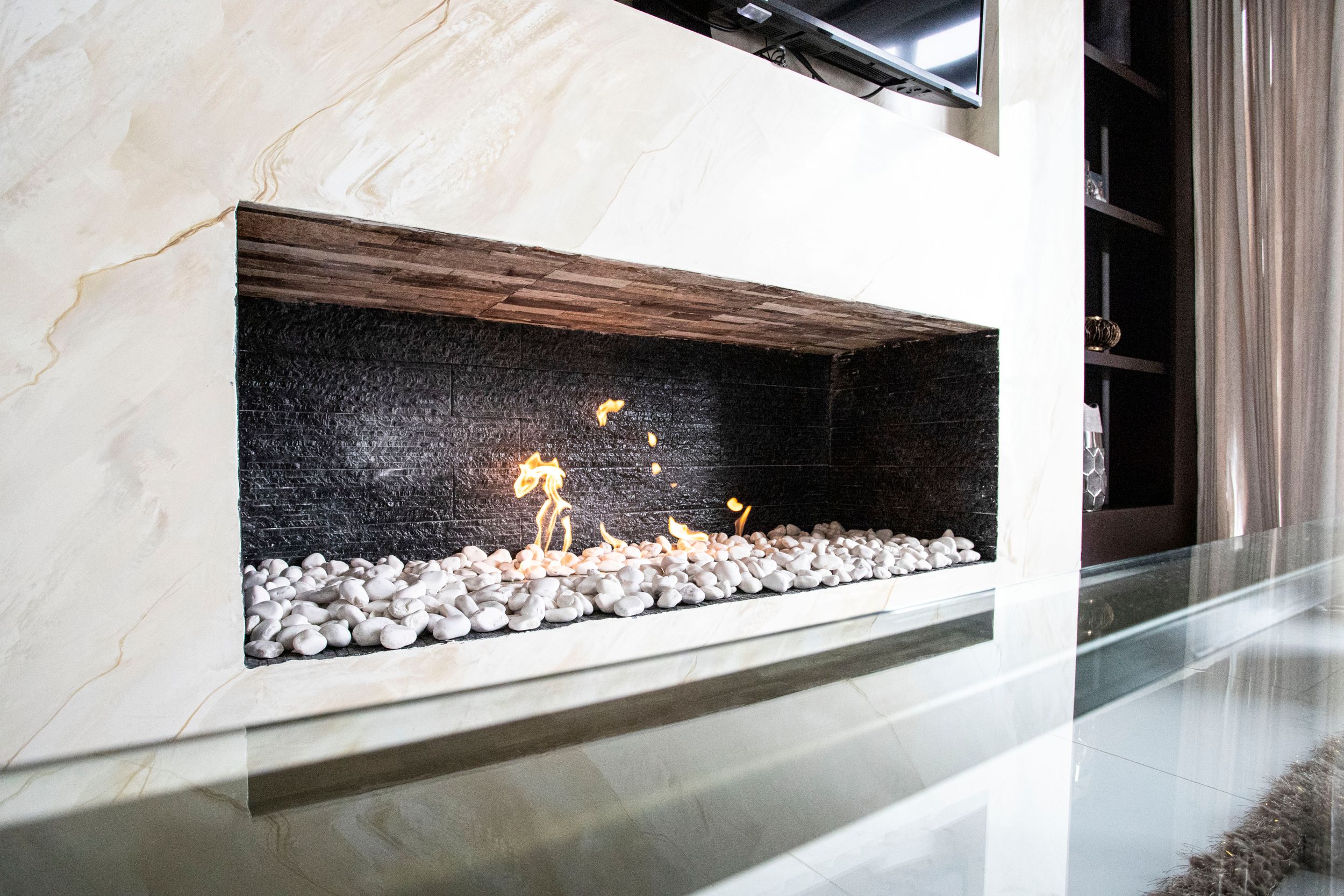 Elegant modern fireplace with a minimalist design, showcasing white stones and soft flames for a cozy ambiance